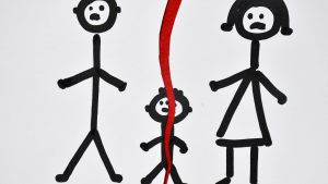 Un disegno di una coppia sposata e di un bambino.  * Il disegno è strappato in due parti sopra il bambino.