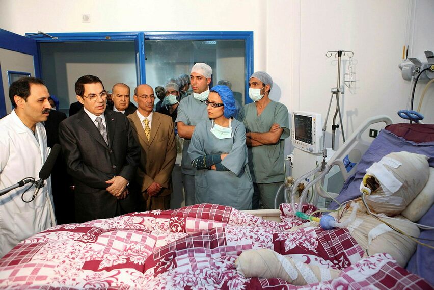 Una foto di allora - L'amministrazione del presidente Ben Ali mostra il presidente in visita a Mohamed Bouazizi, che si è dato fuoco per protestare contro gli abusi della polizia e la povertà, in ospedale nel 2010.