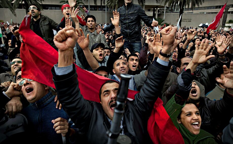 La rivoluzione del 2011: una grande folla si raduna davanti all'odiata sede del partito di governo.  Quando lo striscione del partito di governo è stato demolito, i canti non hanno avuto limiti.