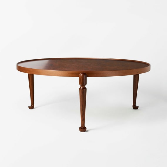 Forme circolari, bordi e materiali misti erano caratteristici di Joseph Frank.  Il tavolino 2139 ha un piano in radica di allume e gambe in noce.