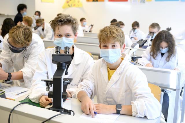 Gli studenti Sofia e Kimo frequentano il primo ciclo presso l'Istituto Tecnico Max Valer di Bolzano.  Qui esaminano piccoli organismi in un piccolo armadietto durante una lezione di biologia.