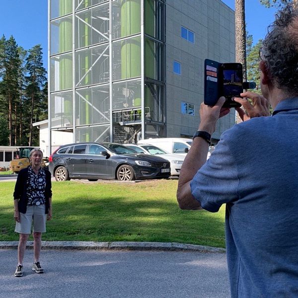 Un uomo scatta una foto a una donna con un telefono cellulare